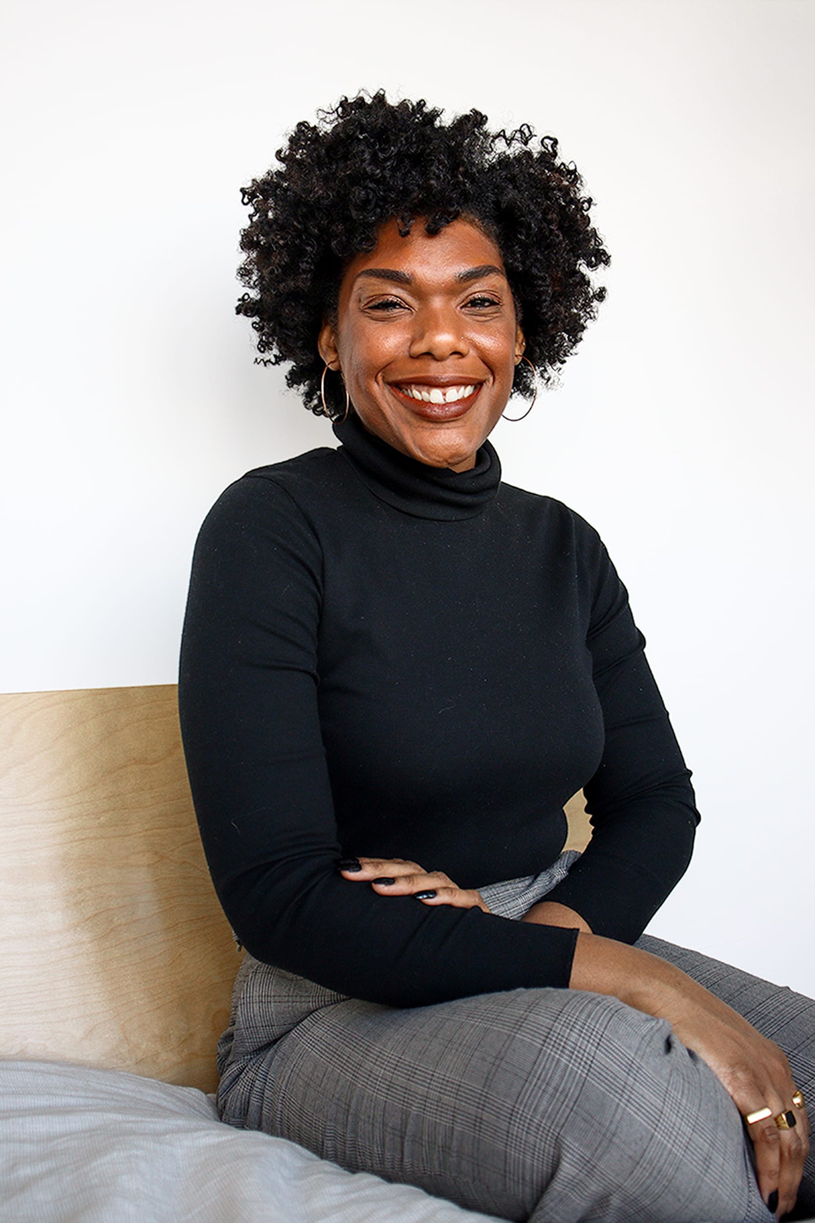 Photo of Minaa B. sitting and smiling